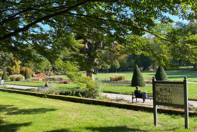 Blick in den blühenden Kurpark bei Sonnenschein.