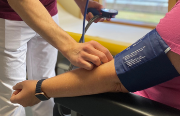 Blutdruckmessen mit einer Blutdruckmanschette und Stethoskop Blutdruckmessen mit einer Blutdruckmanschette und Stethoskop