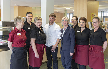 Teambild aus Service Personal und einem Koch.